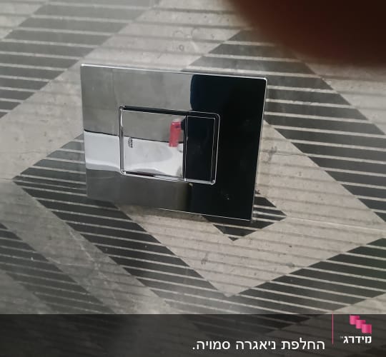 לחצן הדחה כרום על קיר אריחים